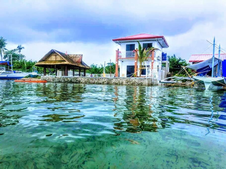 Lapu Lapu City的住宿－PRIVATE COLLECTION 贅沢 Jade's Beach Villa 별장 Cebu-Olango An exclusive private beach secret，船旁水面上的房屋