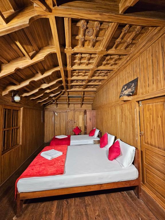 1 dormitorio con 2 camas en una habitación de madera en Nature Castle, en Kottakamboor