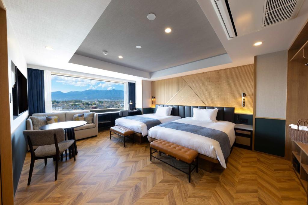 two beds in a hotel room with a view at AQA Hotel Premium in Saku