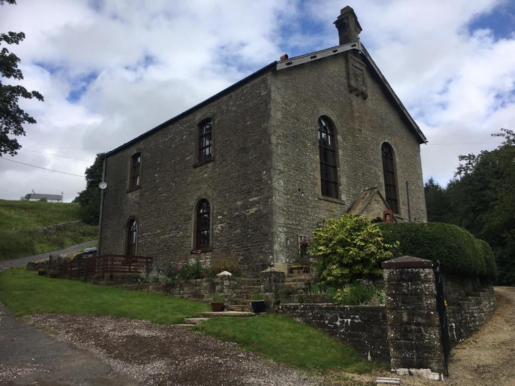 an old brick church on the side of a hill at Beldy Chapel Ground floor apartment in Alston