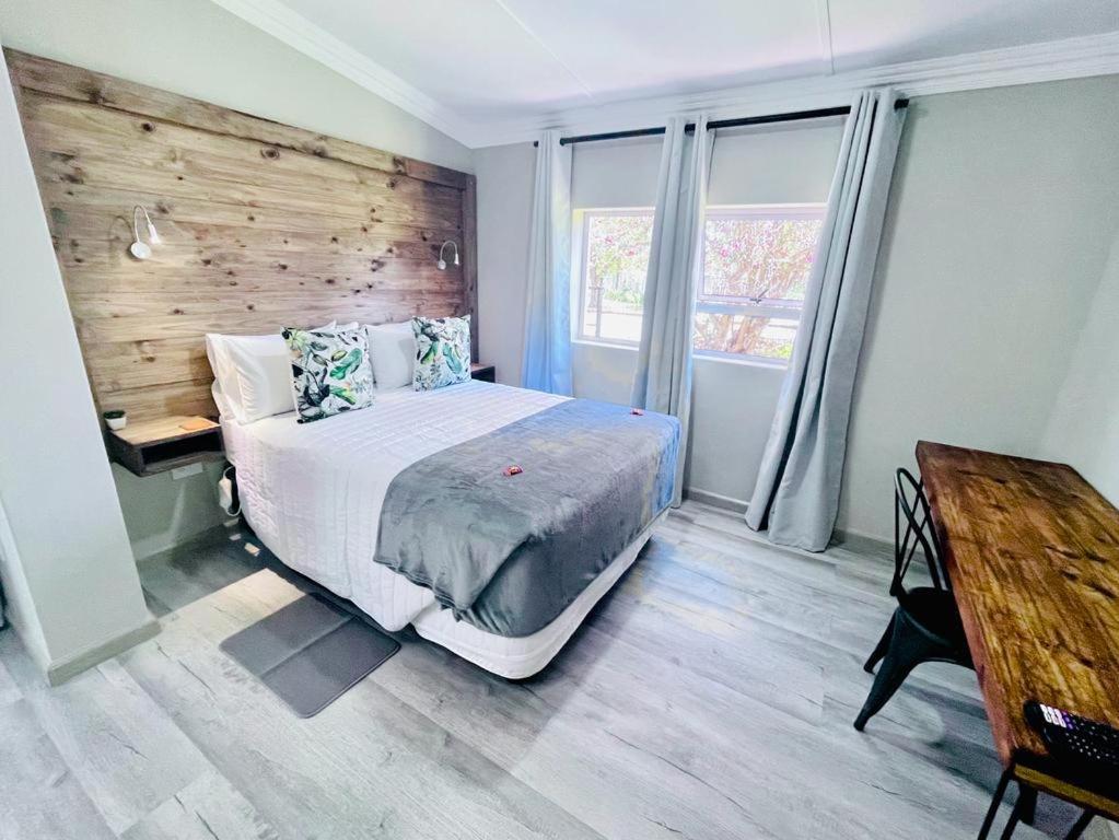 - une chambre avec un lit et un mur en bois dans l'établissement Madeira Bed, à Queenstown