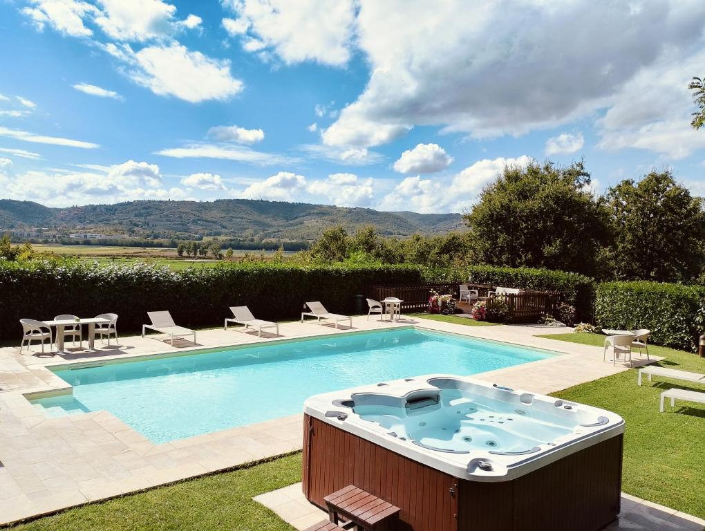 una piscina con sillas y una mesa en Villa Tuscan Prestige 25 ospiti Piscina Jacuzzi, en La Croce