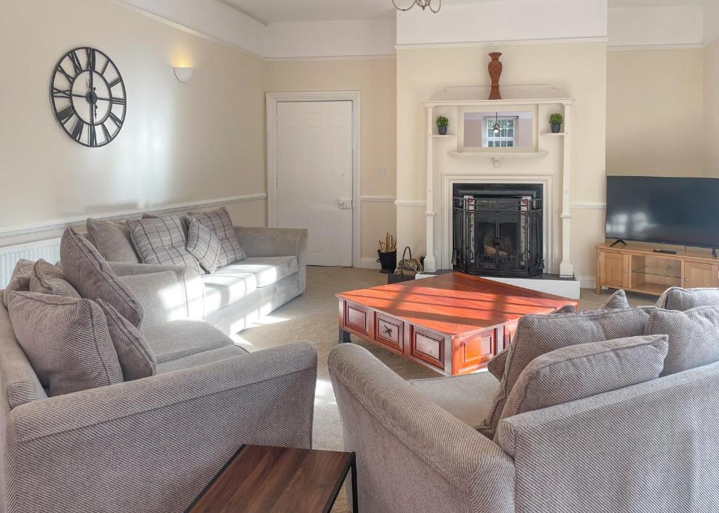 a living room with two couches and a fireplace at Haveringland Hall in Cawston