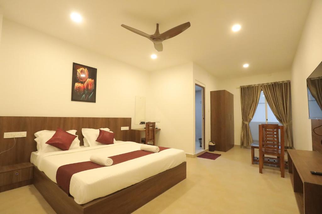 a bedroom with a large bed with a ceiling fan at Hotel Dream Suite, Kattappana in Kattappana