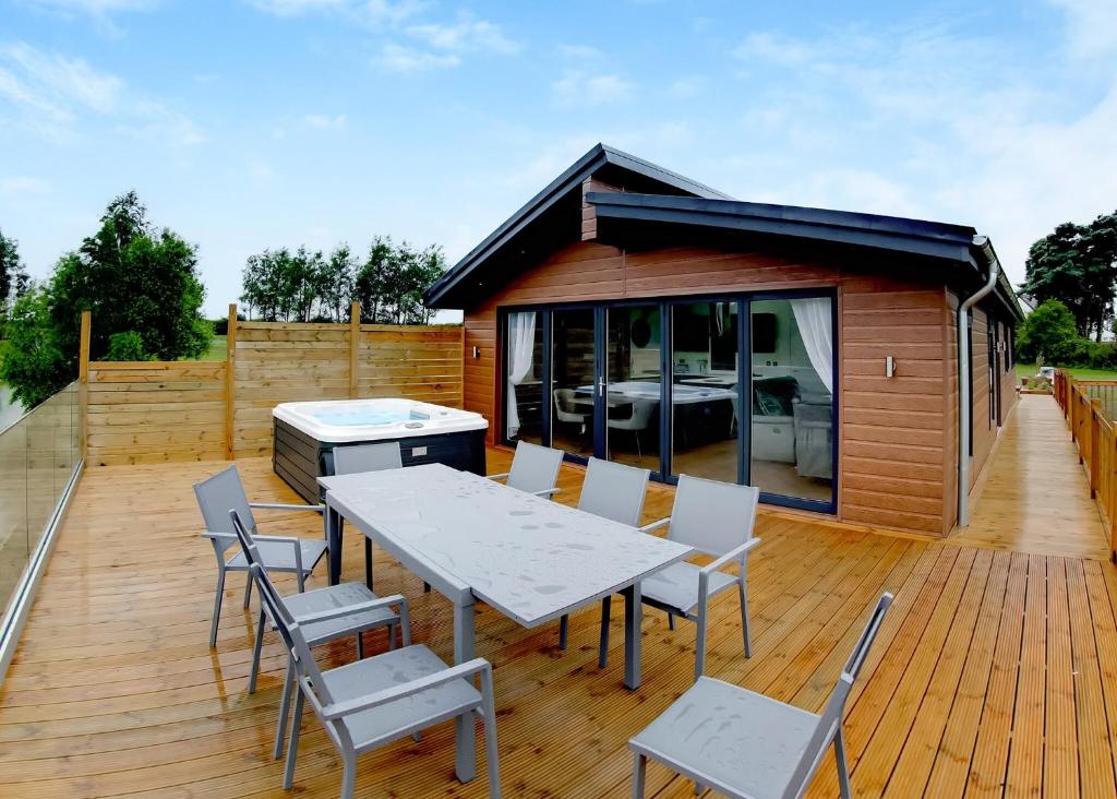 una terraza con mesa y sillas y una casa en Noahs Retreat en Laceby