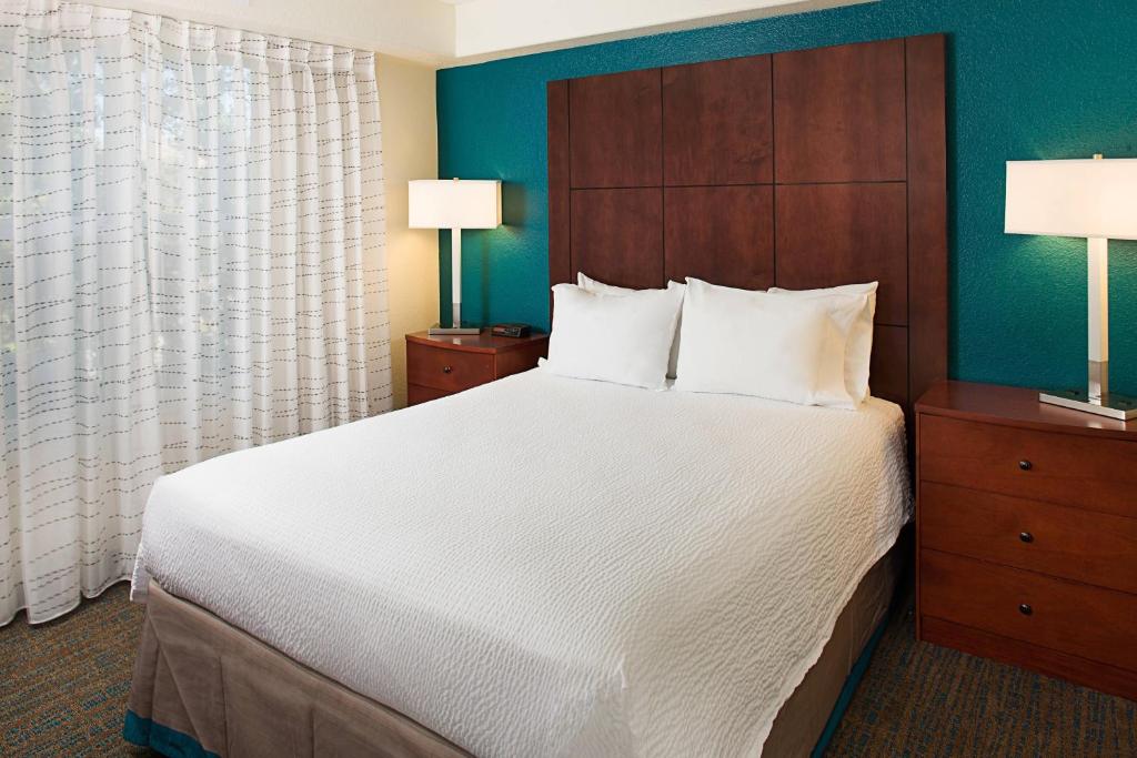 a bedroom with a large bed and two lamps at Residence Inn San Jose South in San Jose