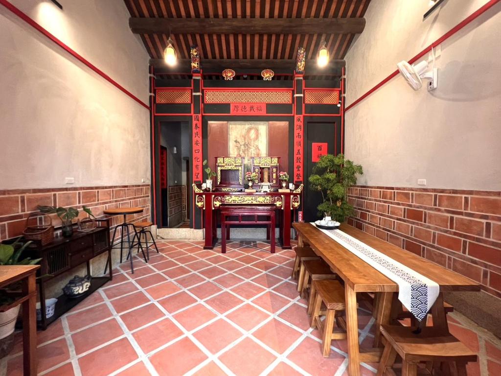 um quarto com uma mesa e bancos num edifício em 壹樓文旅 em Jinhu