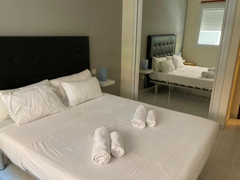 een slaapkamer met 2 bedden en witte handdoeken bij El Medano by Agüita Salada Suites in El Médano