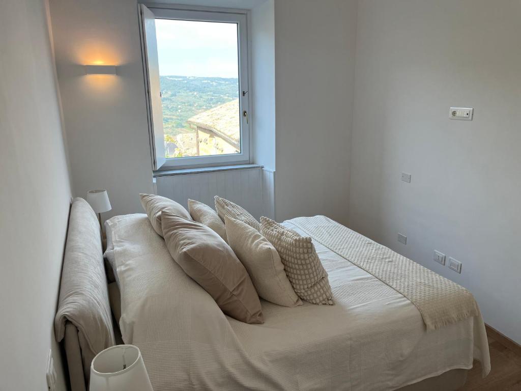 a bed in a white room with a window at Appartamento con terrazzo in Orvieto