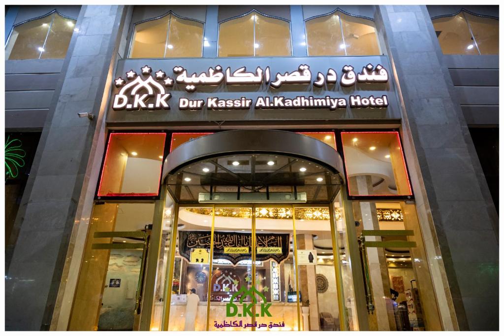 un magasin à l'avant d'un bâtiment muni d'un panneau. dans l'établissement Dur Kassir Alkadhimiya Hotel, à Karbala