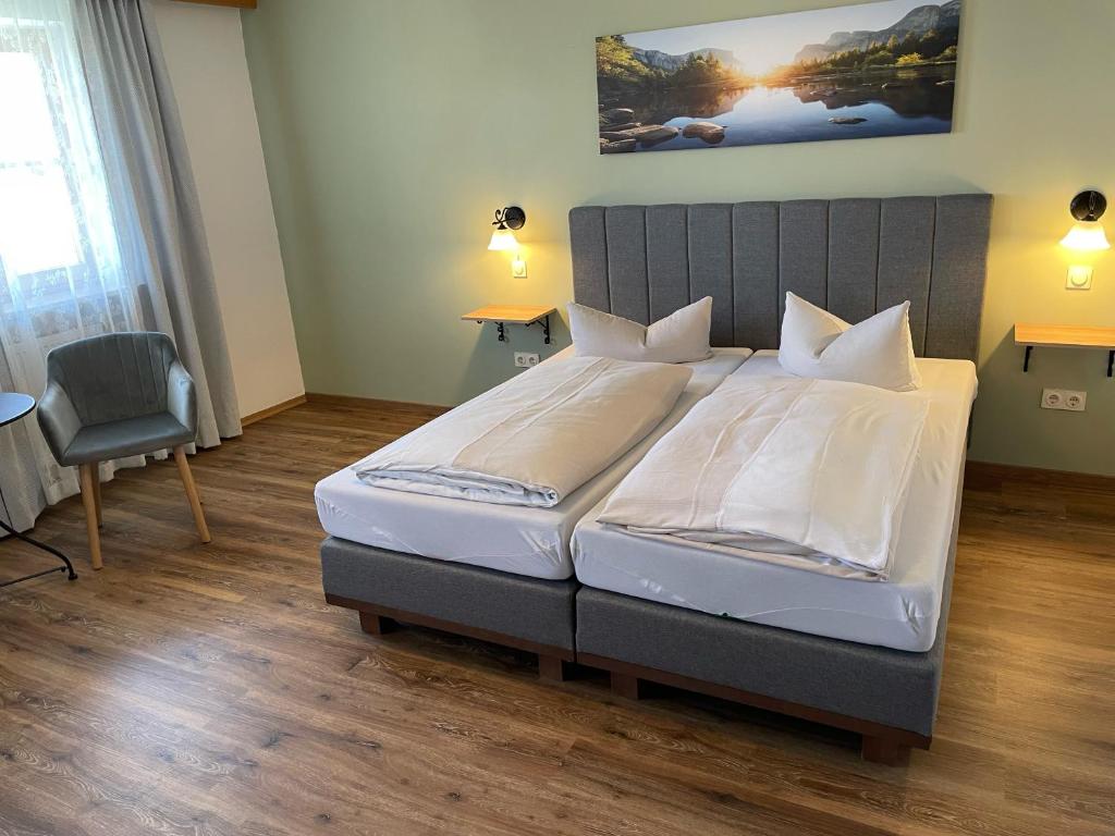 een slaapkamer met een bed, een tafel en een stoel bij Hotel Garni Kern in Halfing