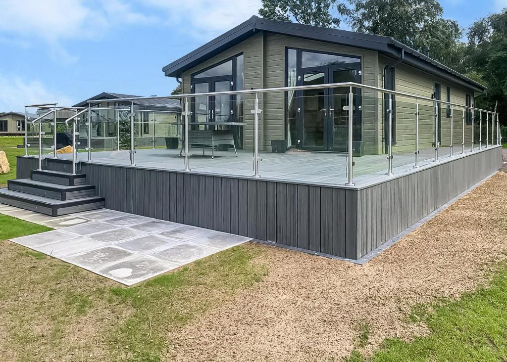 a modular house with a large deck with glass windows at Lakeside Luxury Lodges in Thorney