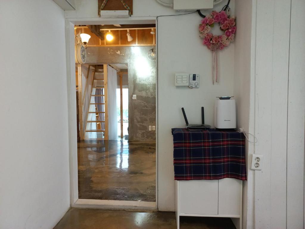 a hallway with a door leading into a room at Yeongildae Stay in Pohang