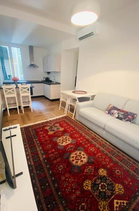 a living room with a white couch and a red rug at Nuovissimo trilocale in centro : Ca’ Del Mar in Sanremo