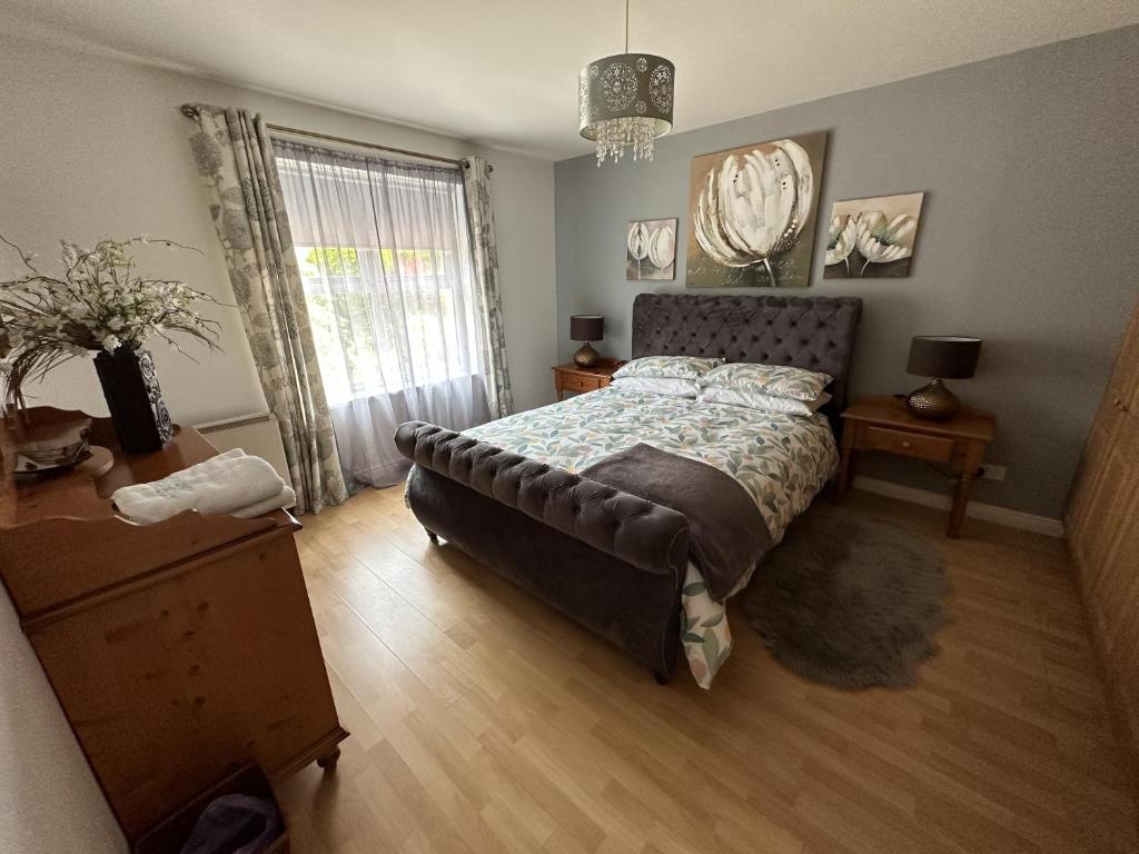a bedroom with a bed and a dresser and a window at Coleraine Riverside apartment in Coleraine