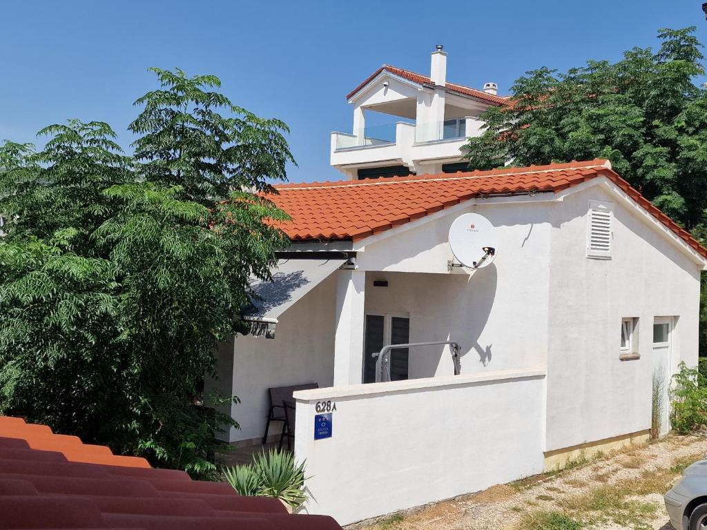 a white house with a red roof at Vikendica Nika in Rab