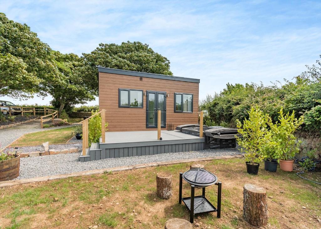 a tiny house with a patio and trees at Calvesland Hideaway in Manorbier