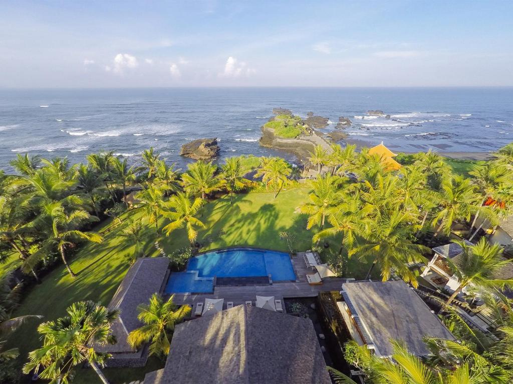 an aerial view of a resort with a swimming pool and the ocean at Villa Semarapura in Canggu