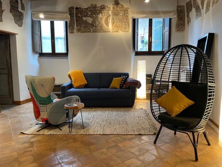 - un salon avec un canapé bleu et deux chaises dans l'établissement Bella Casa Affrescata, à Orvieto