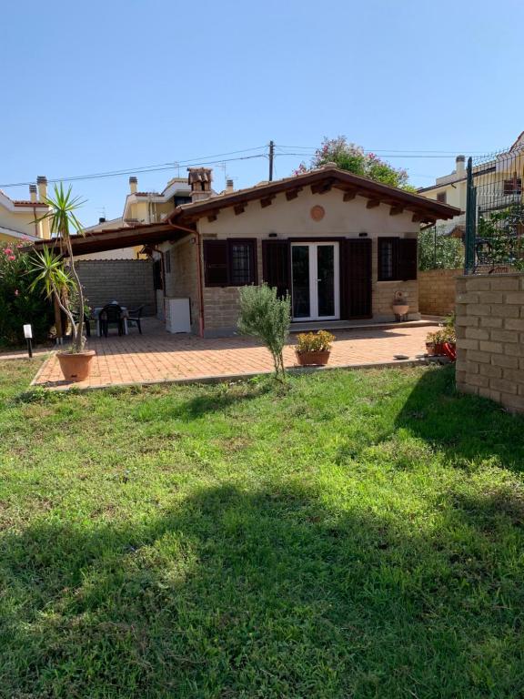 a small house with a patio and a yard at Chalet al Mare in Civitavecchia