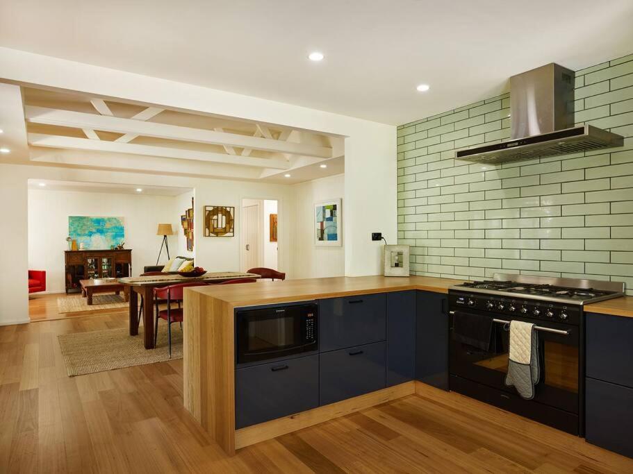 a kitchen with blue cabinets and a dining room at Bushland retreat in Gold Coast