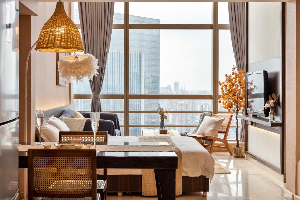 - un salon avec une table et une grande fenêtre dans l'établissement Raffles Executive Apartment - Guangzhou Zhengjia Plaza Sports West Road StationBranch -Canton Fair Free Shuttle, à Canton
