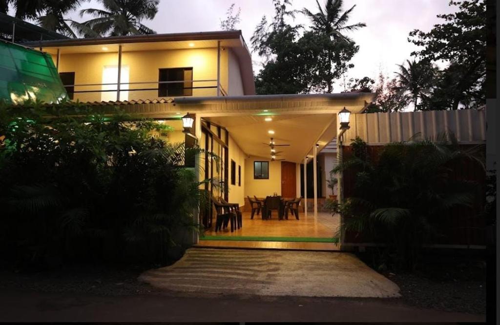 a house with a porch and a dining room at SAVI 4BHK VILLA ALIBAUG in Alibaug