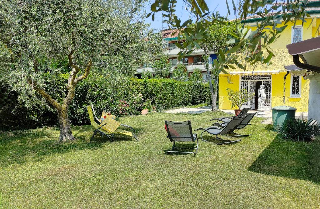 un grupo de sillas sentadas en un patio en Villa con giardino privato, tre camere, due bagni, en Manerba del Garda