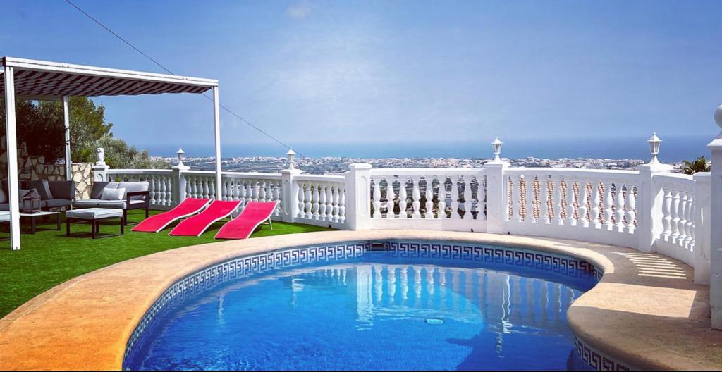una piscina en un balcón con una valla blanca en VILLA FAMILIA, en Denia