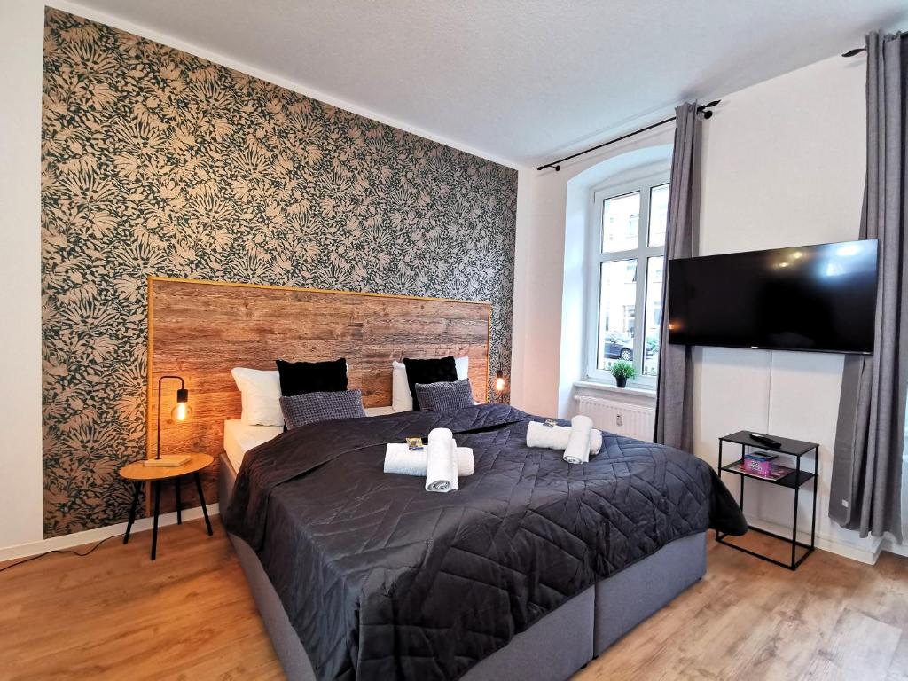a bedroom with a large bed and a tv at BohnApartments Studio M City - Domplatz - WLAN - Vollausstattung in Erfurt