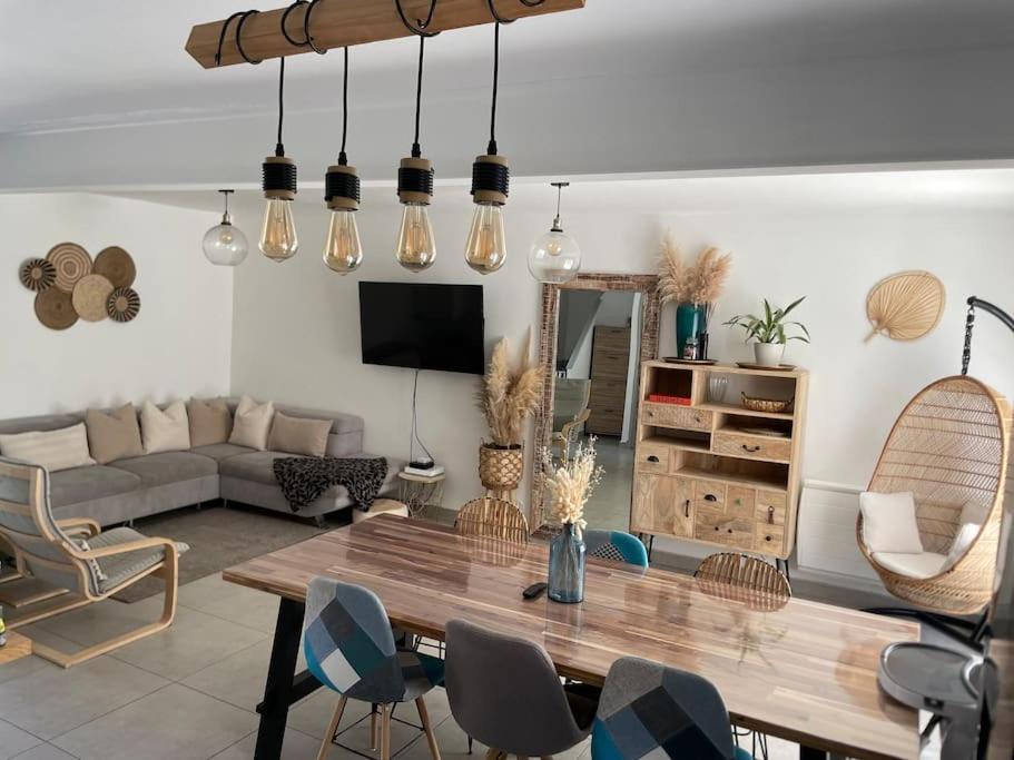 un salon avec une table et des chaises en bois dans l'établissement Agréable maison de ville à 500 mètres de la cité, à Carcassonne