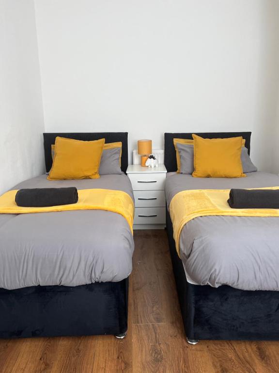 two beds sitting next to each other in a bedroom at spacious 3 bed - EFC stays in Liverpool