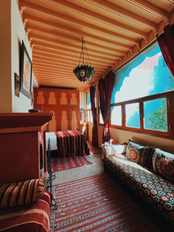 a living room with a couch and a large window at Riad Al Nour in Marrakech