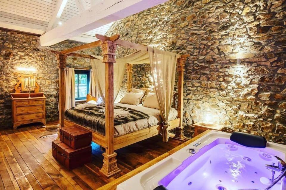 Érezée的住宿－Le Sanglier Amoureux，一间卧室配有一张床和一个浴缸