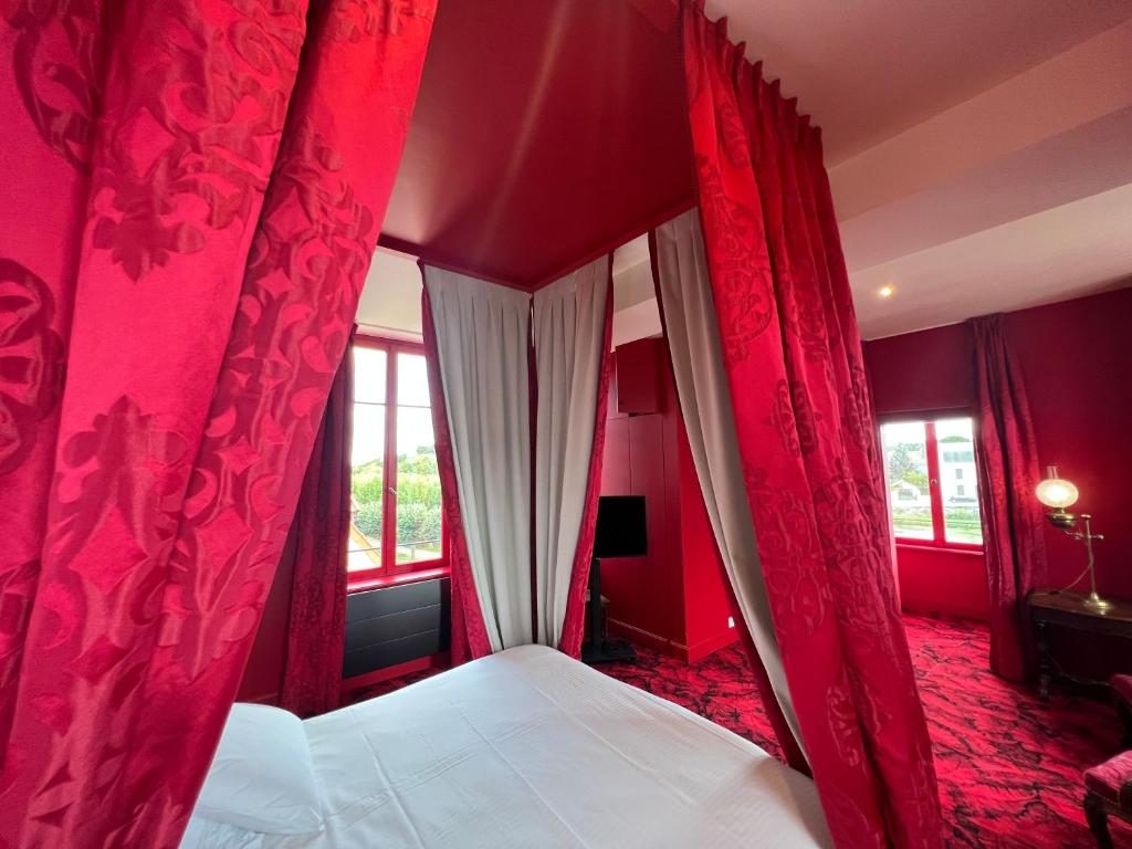 a red bedroom with a bed with red curtains at La Maison à Pan De Bois Chambre Napoléon III in Vierzon