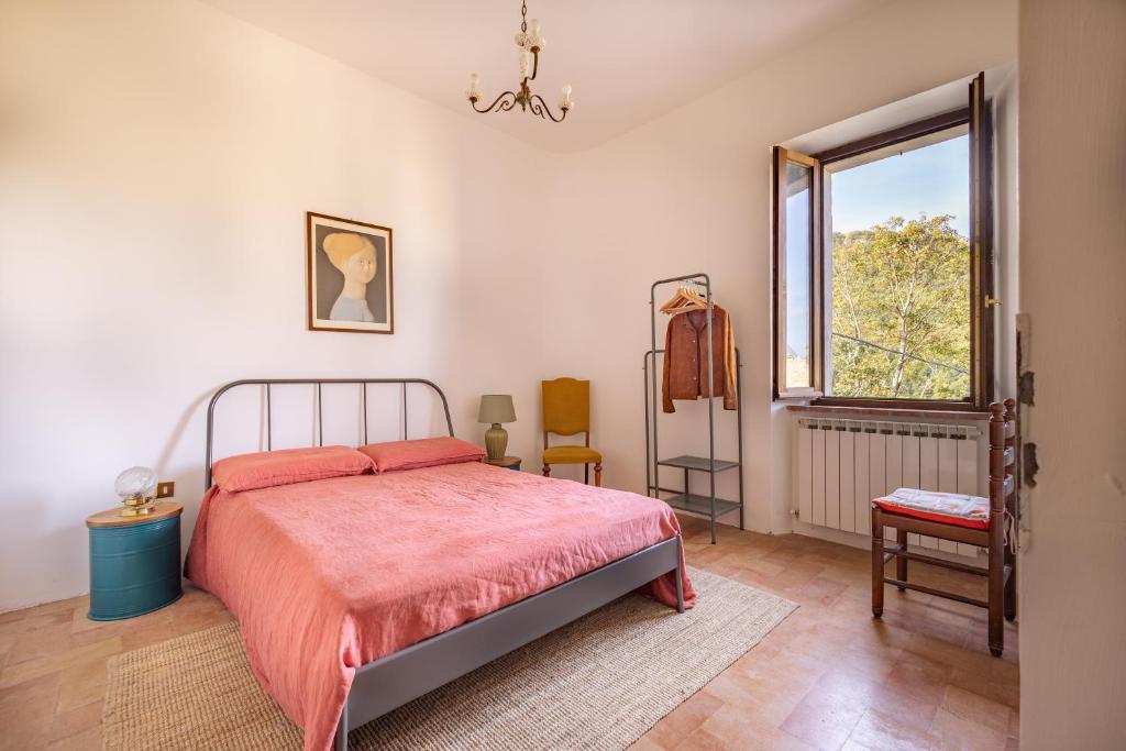 a bedroom with a bed and a window at Casa Lola nel centro storico di Bolognola in Pintura di Bolognola