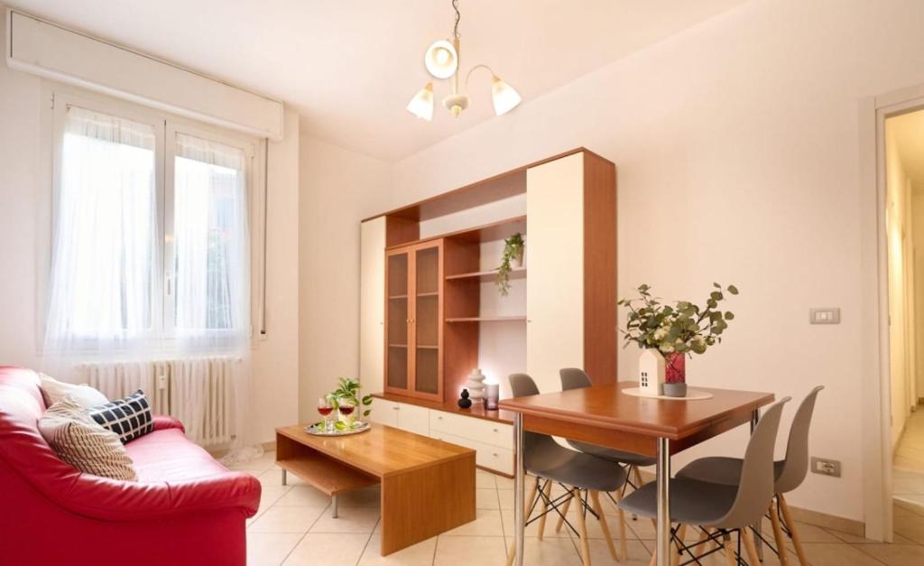 a living room with a table and a red couch at HomeSerra 2 in Bologna