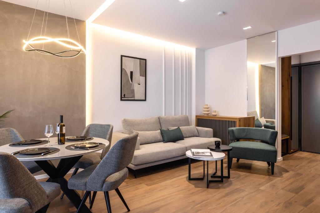 a living room with a couch and a table and chairs at The five star apartment in Thessaloniki