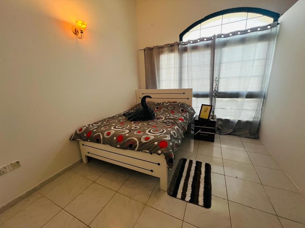 a bedroom with a bed in a room with a window at Al-Satwa Central Bliss: Ideal for Families in Dubai