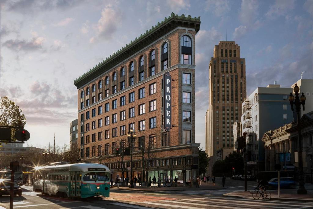 un autobús conduciendo por una calle frente a un edificio en San Francisco Proper Hotel, a Member of Design Hotels, en San Francisco