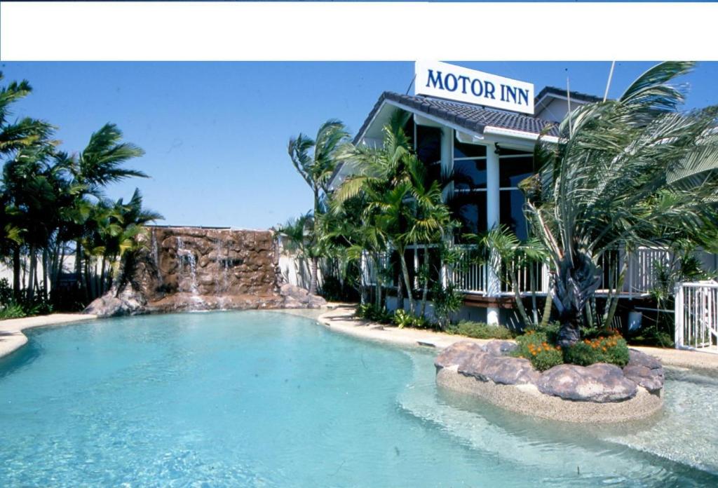 a swimming pool in front of a hotel at Runaway Bay Motor Inn in Gold Coast