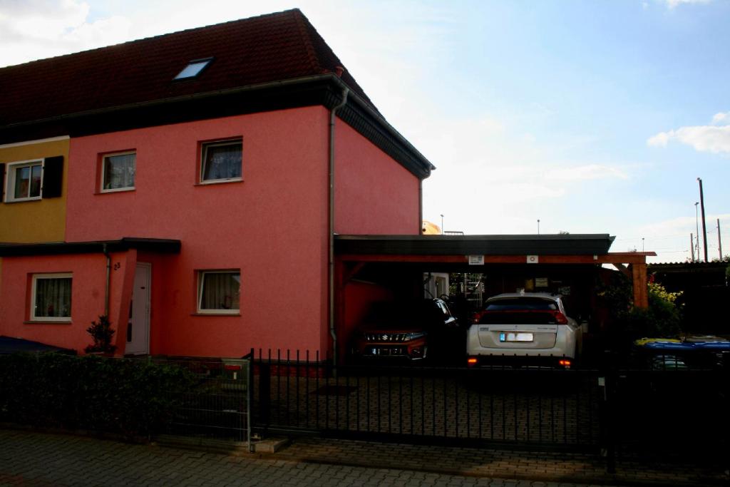 ein rotes Haus mit einem Auto in einer Garage in der Unterkunft Ferienwohnung Annett in Böhlen