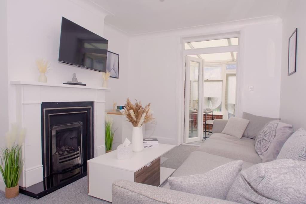 sala de estar con sofá y chimenea en Vibrant 4 Bedroom House With Game Area & Garden en Southampton