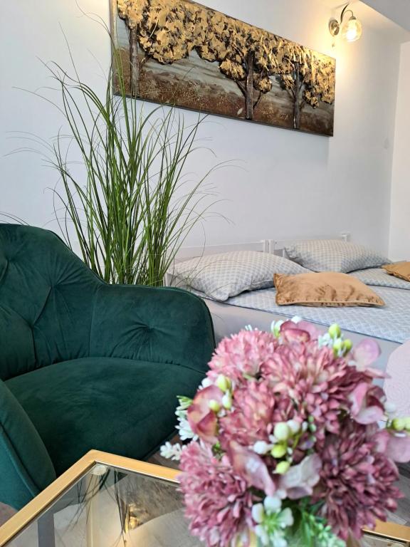 ein Wohnzimmer mit einem Sofa und einem Glastisch mit Blumen in der Unterkunft 7 Levél Central Apartments in Miercurea Ciuc