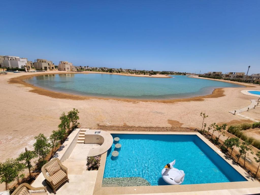 - une piscine sur une plage avec une masse d'eau dans l'établissement Luxury 4 bedroom villa - Cyan ElGouna, à Hurghada