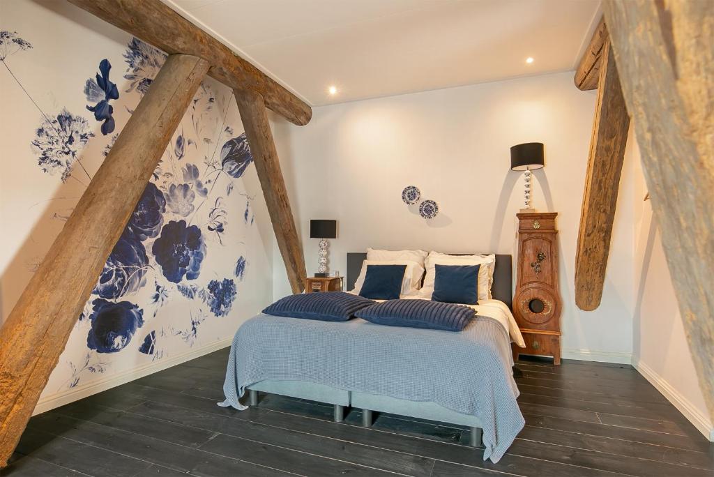 um quarto com uma cama azul e branca em Inn Friesland em Ternaard