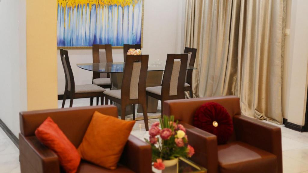 a living room with a couch and a table with chairs at Jeffston Court Apartments in Accra