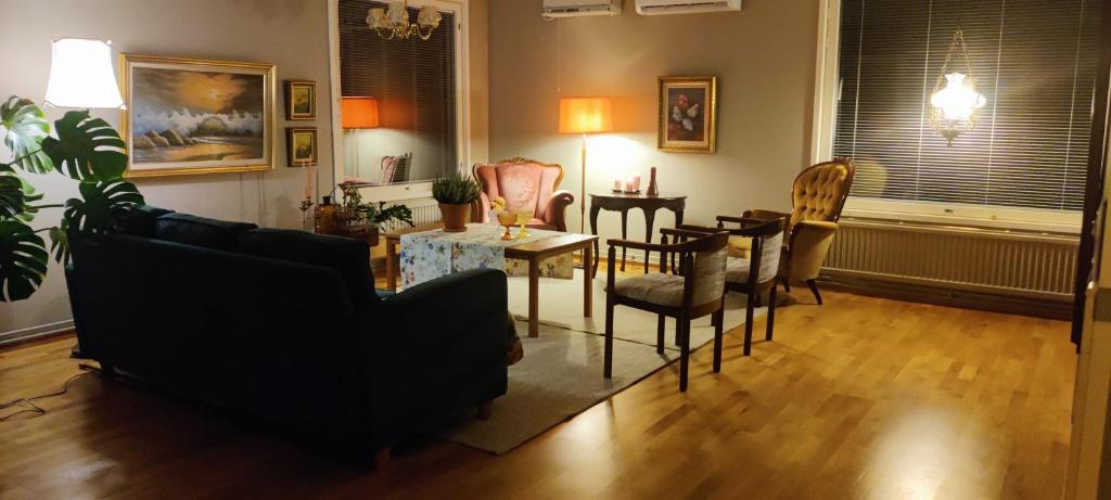 ein Wohnzimmer mit einem Sofa, einem Tisch und Stühlen in der Unterkunft Riverside country house in Rovaniemi
