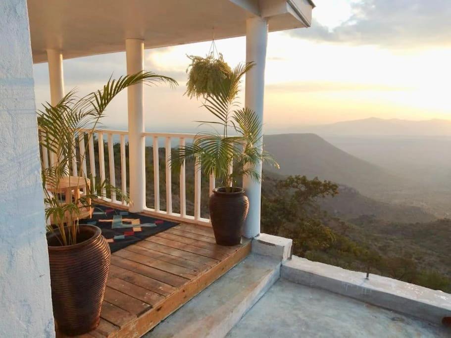 a porch with potted plants on it with a view at harmonious two bed cottage with breathtaking views in Kajiado