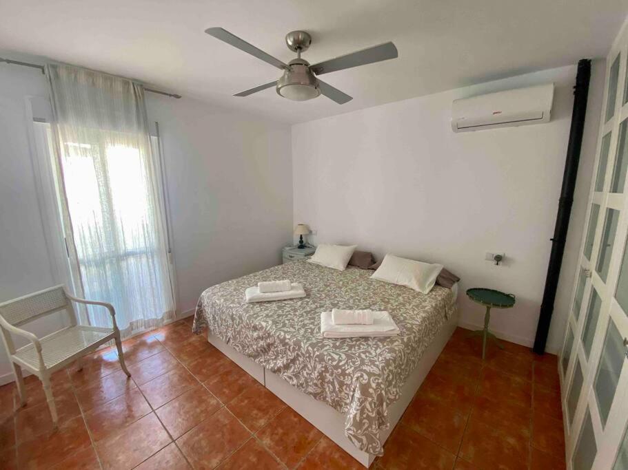 una camera con letto e ventilatore a soffitto di Duplex con terraza en Agua Amarga a Agua Amarga